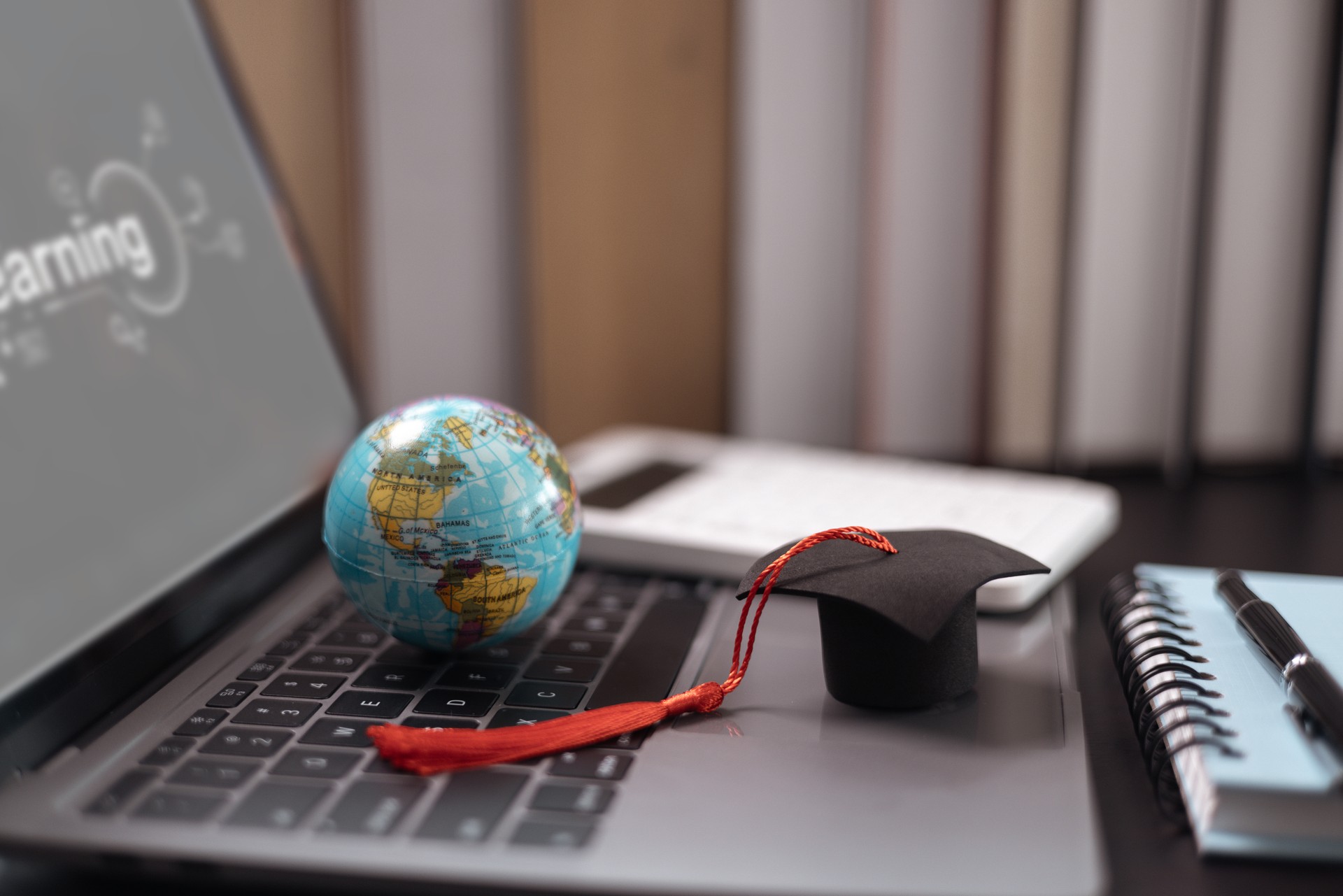 Graduate, diploma in global business, reflected on academic journey, which began as student studying diligently at college, ready to make an impact on earth. degree, graduation, abroad, book, hat.