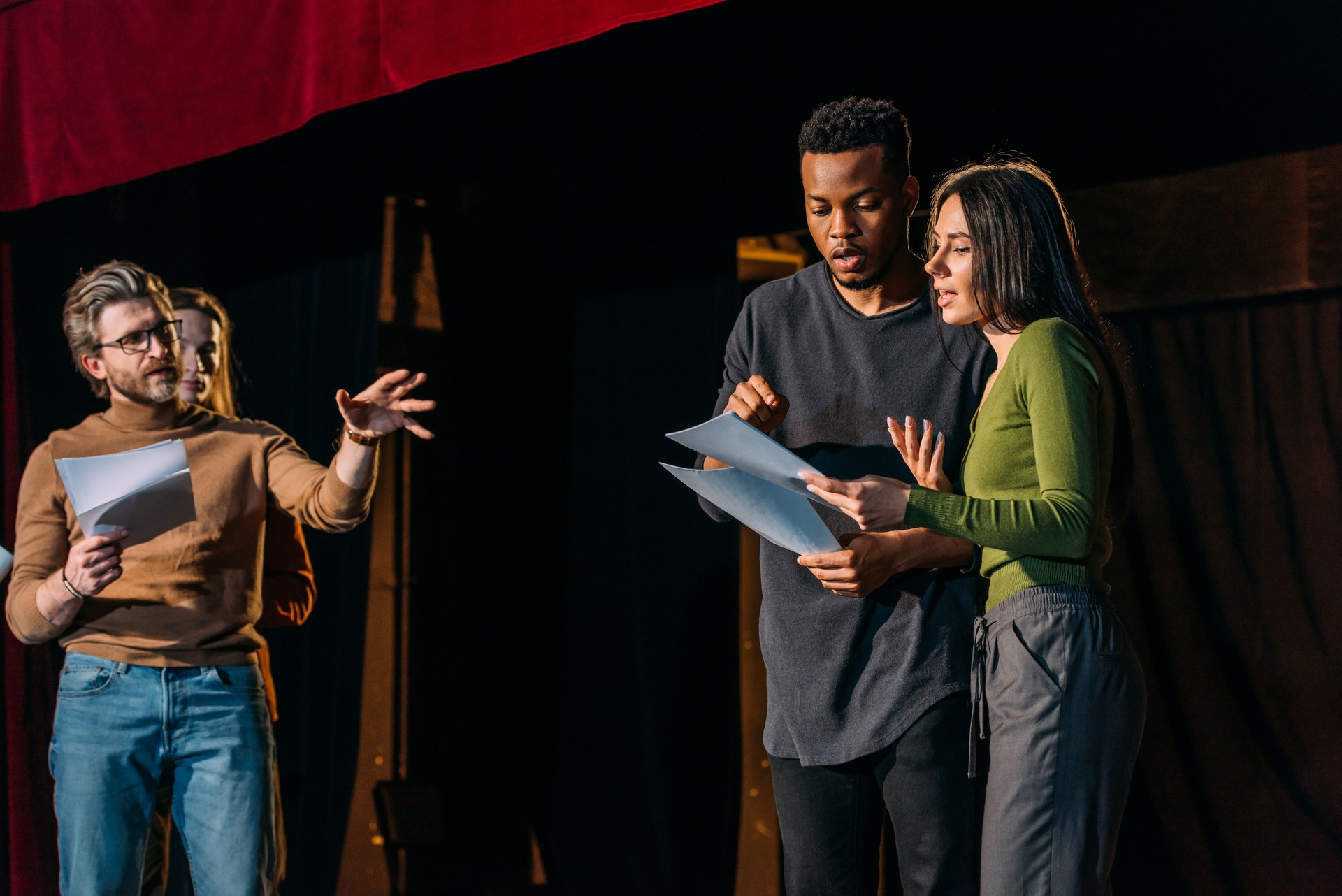 theater director, multicultural actors and actress rehearsing on stage